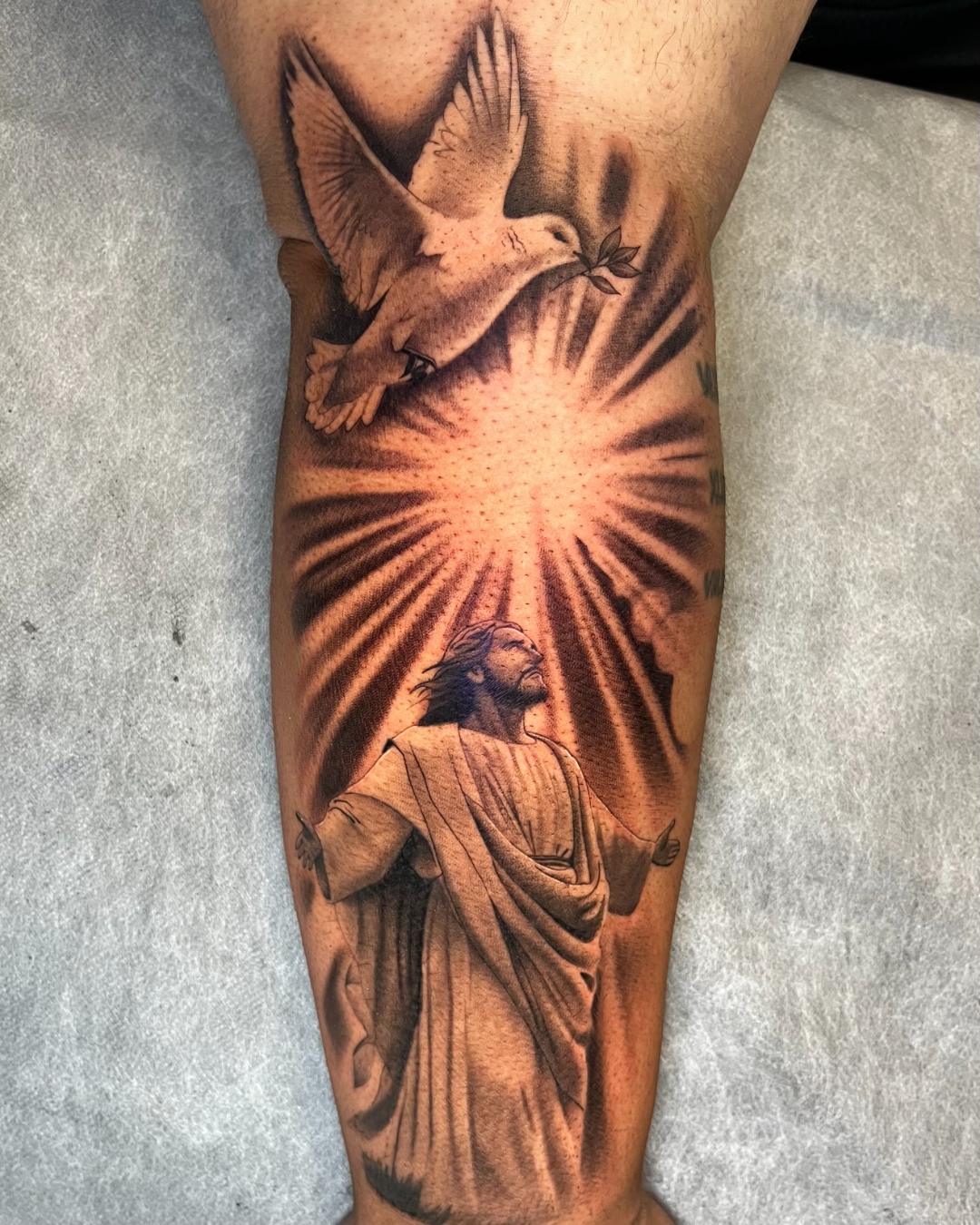 Black and grey realism religious tattoo with radiant sunburst by Final Touch Tattoo
